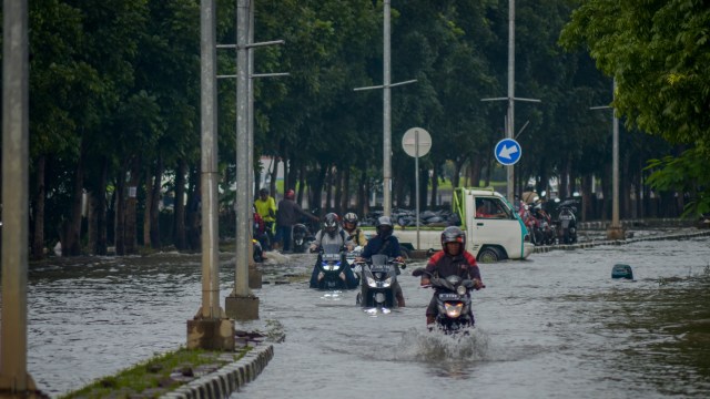 Pengendara motor menerjang banjir yang mengenang Jalan Cimincrang, Gedebage, Bandung, Jawa Barat, Sabtu (25/1/2020). Foto: ANTARA FOTO/Raisan Al Farisi