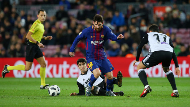 Aksi Messi saat laga menghadapi Valencia. Foto: REUTERS/Albert Gea