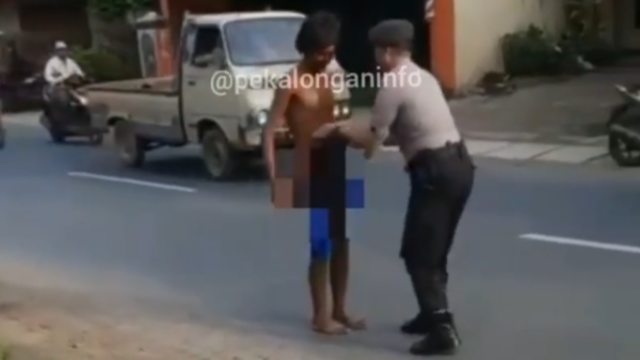 Seorang polisi di Pekalongan, Iptu Turkhan memakaikan celana ke orang dengan gangguan jiwa (ODGJ) yang telanjang. Foto: Instagram @pekalonganinfo