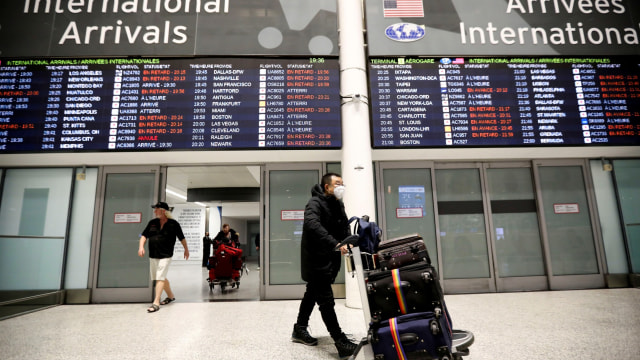 Wisatawan menggunakan masker berdatangan di Bandara Pearson, Torontom Ontario, Kanada. Foto: REUTERS / Carlos Osorio