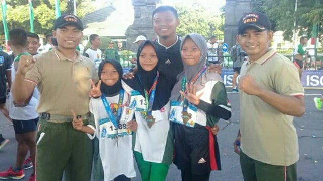 Siti Frida Nuryanti, Lira Selviana, dan Luthfi Nurul Fadhila, usai menerima medali pada event Brawijaya Run 10K, di Makodam V Brawijaya Surabaya. Minggu (26/01/2020) 