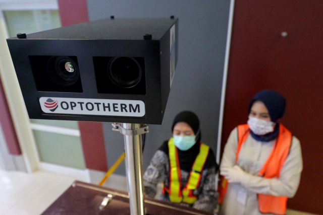 Petugas KKP Pangkalpinang mengoperasikan alat deteksi suhu tubuh atau "thermoscan" di Bandara Depati Amir, Pangkalpinang, Kepulauan Bangka Belitung. Foto: ANTARA FOTO/Anindira Kintara