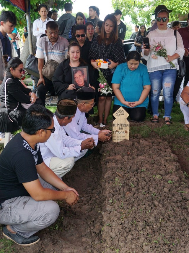 Keluarga berdoa di pusaran makam Johny Indo di TPU Selapajang Jaya, Tangerang, Senin (27/1/2020). Foto: Nugroho Sejati/kumparan