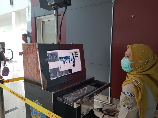 Petugas kesehatan dari kantor kesehatan pelabuhan koordinator wilayah kerja Bandara Depati Amir, saat memantau suhu tubuh dengan Alat Thermo Scanner.