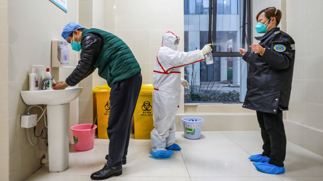 Petugas medis disemprot disinfektan sebelum masuk ke rumah sakit di Wuhan di Provinsi Hubei, China.
 Foto: STR / AFP
