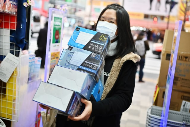 Seorang pelanggan membeli masker dari toko obat di daerah Akihabara Tokyo.  Foto: AFP/CHARLY TRIBALLEAU