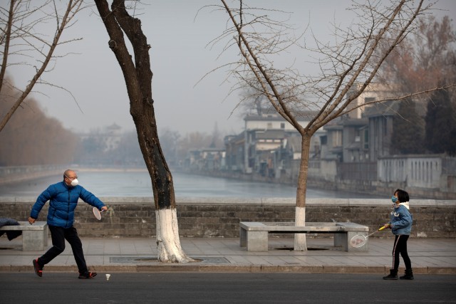 Warga menggunakan masker bermain bulutangkis di Beijing, China. Foto: AP / Mark Schiefelbein 