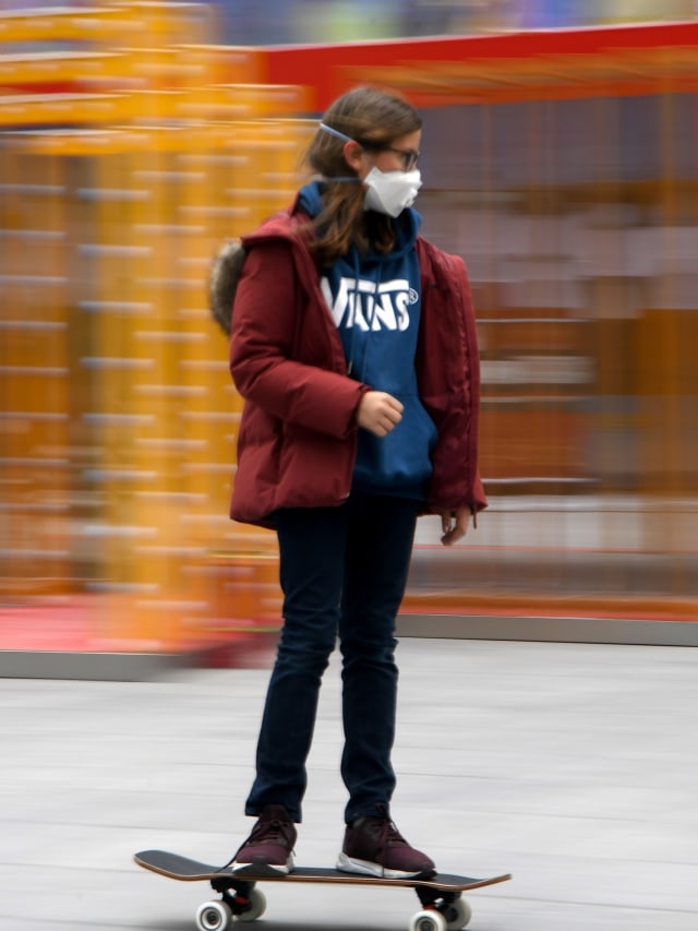 Warga menngunakan masker bermain skateboard di Jalanan Beijing, China.
 Foto: AFP/NOEL CELIS