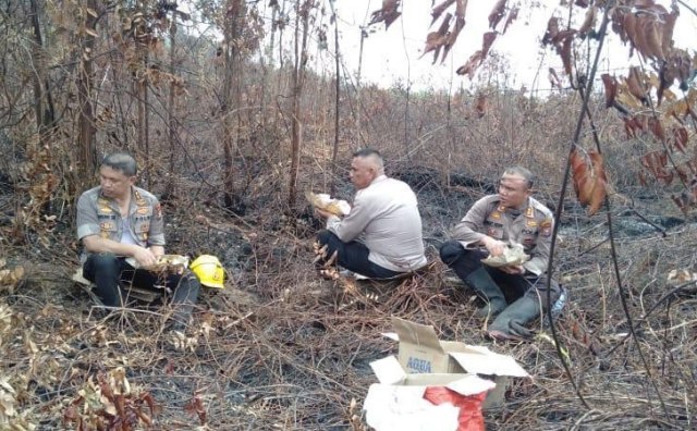KAPOLDA Riau, Irjen Pol Agung Setya Imam Effendi (kiri) saat makan nasi bungkus usai ikut serta dalam pemadaman api Kebakaran Hutan dan Lahan (Karhutla) di Pulau Rupat, Bengkalis, Senin, 27 Januari 2020. 