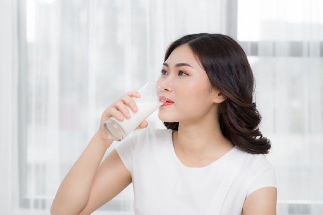 com-Ilustrasi wanita sedang minum susu dengan kandungan asam folat Foto: Shutterstock