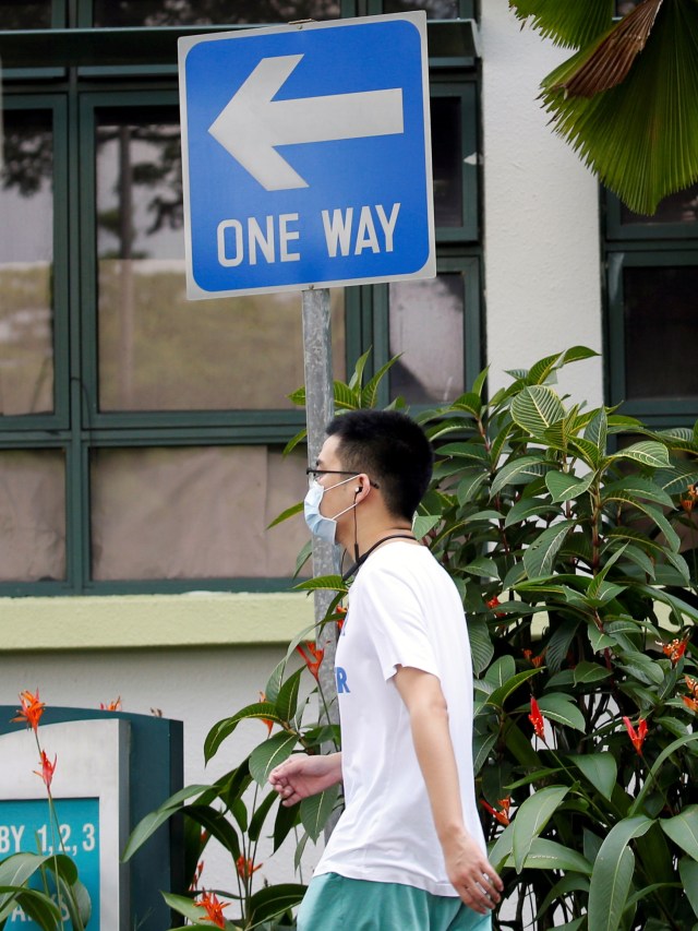 Seorang siswa berjalan di area asrama yang digunakan sebagai zona karantina di Universitas Teknologi Nanyang di Singapura. Foto: REUTERS / Feline Lim