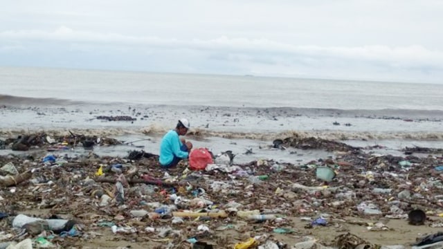 Seorang pemulung mengutip sampah di Pantai Padang, Sumatera Barat (Foto: Adi S/Langkan.id)