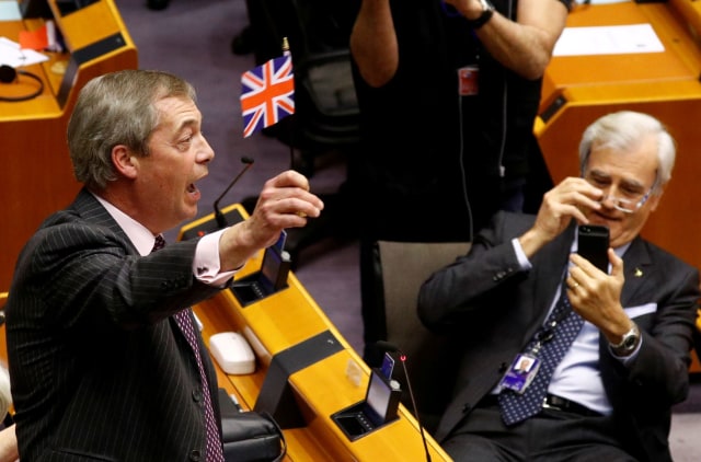 Anggota parlemen Eropa mengibarkan bendera Inggris usai voting ratifikasi brexit. Foto: Yves Herman/Reuters