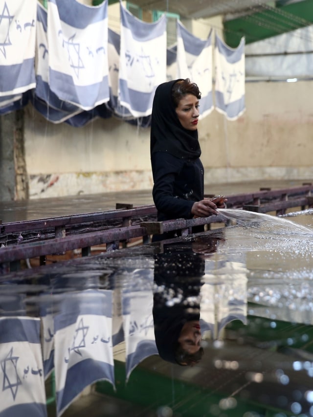 Pabrik bendera Amerika Serikat dan Israel di Khomein City, Iran. Foto: Nazanin Tabatabaee/WANA via REUTERS