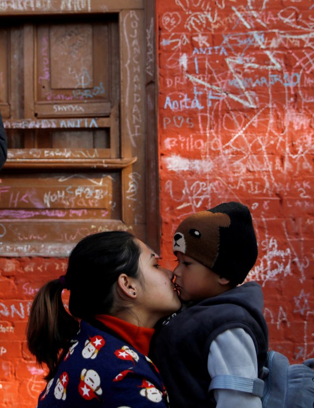 Seorang wanita mencium seorang anak di Kuil Saraswati saat festival Shreepanchami di Kathmandu, Nepal, Kamis (30/1). Foto: REUTERS / Navesh Chitrakar