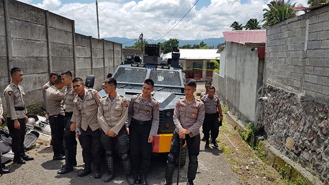 Polisi berjaga-jaga di jalan masuk menuju balai pertemuan yang difungsikan sebagai musala di Perumahan Agape, Desa Tumaluntung, Kecamatan Kauditan, Kabupaten Minahasa Utara, Sulawesi Utara.