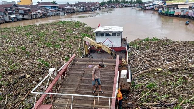 Kapal Sapu-sapu membersihkan sampah kayu di Sungai Martapura, bawah Jembatan Pasar Lama, Banjarmasin pada Jumat (31/1/2020). M Syahbani/banjarhits.id