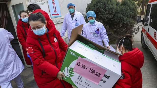 Dokter membawa pasokan medis yang disumbangkan dari Beijing diturunkan di sebuah rumah sakit di Wuhan. Foto: Chinatopix via AP