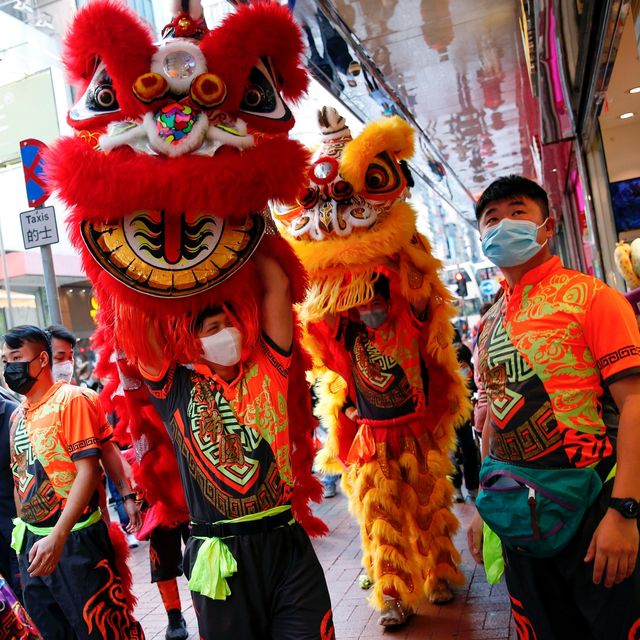 Para pemain barongsai memakai masker ketika mereka berkeliling kota dalam peringatan Tahun Baru Imlek, di Hong Kong, China, Jumat (31/1/2020).  Foto: REUTERS/Tyrone Siu