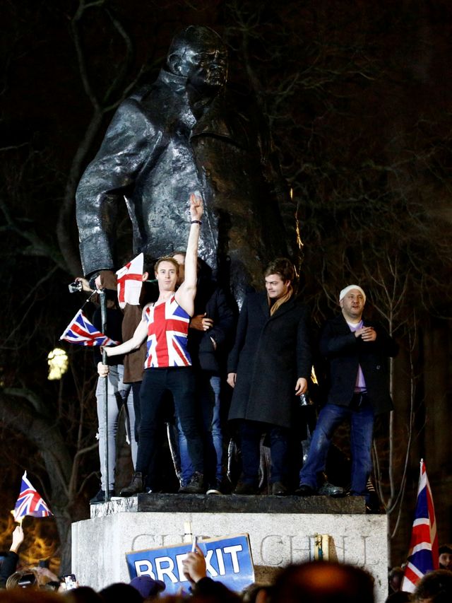 Orang-orang melakukan selebrasi di patung Winston Churchill ketika Inggris meninggalkan Uni Eropa pada hari Brexit di London, Inggris, Jumat (31/1). Foto: REUTERS/Henry Nicholl