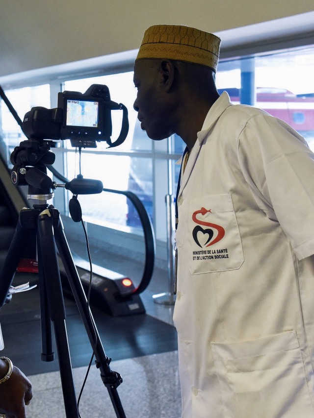 Petugas kesehatan menyiapkan pemindai termal untuk penumpang yang tiba di Bandara Internasional Blaise Diagne di Dakar, Senegal. Foto: AFP/SEYLLOU