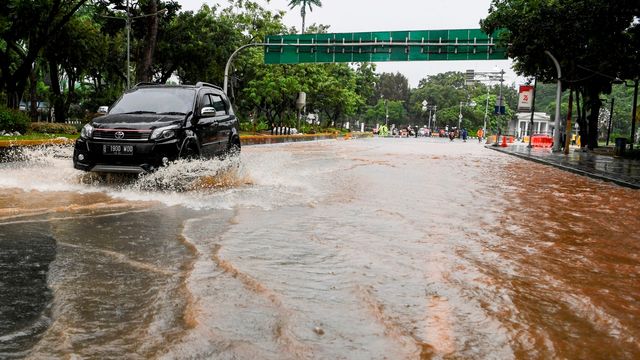 Mobil melintasi banjir di depan Istana Negara, Jalan Medan Merdeka Barat, Jakarta, Minggu (2/2/2020).  Foto: ANTARA FOTO/Hafidz Mubarak A