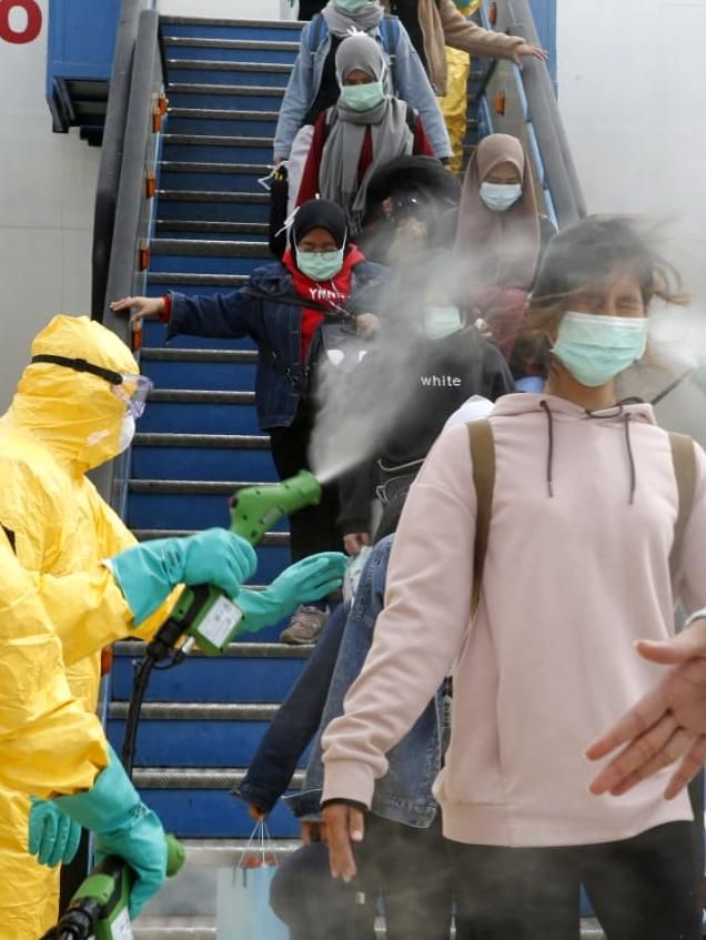 WNI dari Wuhan disemprot cairan desinfektan saat menuruni pesawat di Bandara Hang Nadim, Batam, Kepulauan Riau, Minggu (2/2/2020). Foto: Dok. Kemlu