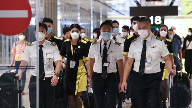 Para awak kabin pasawat mengenakan masker pelindung di Bandara Changi Singapura  Foto: AFP/Roslan Rahman