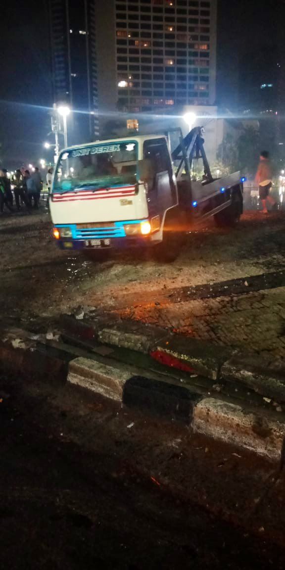 Mobil derek bersiap mengangkat mobil yang tercemplung di kolam Bundaran HI. Foto: Dok. @TMCPoldaMetro