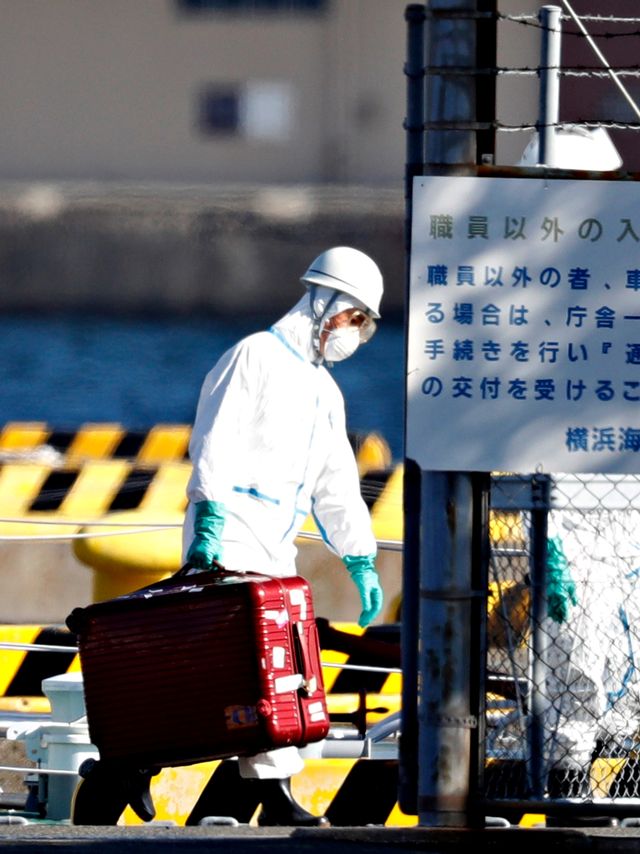 Petugas mengenakan pakaian pelindung tiba di markas polisi maritim dari kapal pesiar Diamond Princess tiba di Yokohama, selatan Tokyo, Jepang. Foto: REUTERS/Kim Kyung-Hoon