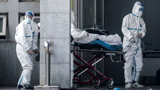 Ilustrasi petugas medis membawa seorang pasien yang diduga terkena virus Wuhan ke rumah sakit Jinyintan, China.  Foto: AFP/STR