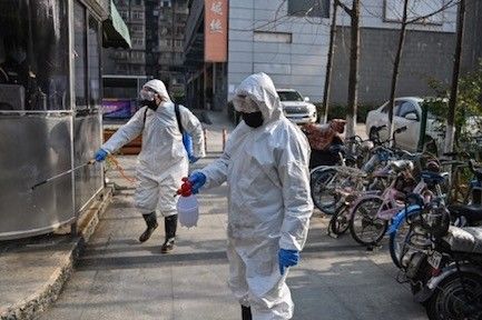 Petugas berpakaian khusus melakukan inspeksi kebersihan terkait Virus Korona di Wilayah Wuhan, Tiongkok (Sumber Gambar: AFP)