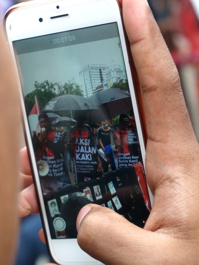 Seorang aktivis Jaringan Solidaritas Korban untuk Keadilan sedang merekam aksi Kamisan ke-621 di depan Istana Merdeka, Jakarta, Kamis (6/2). Foto: Iqbal Firdaus/kumparan