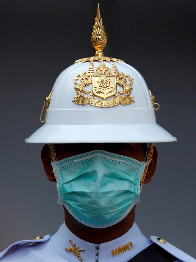 Penjaga Kerajaan Thailand menggunakan masker berjaga di dalam Istana Kerajaan di Bangkok, Thailand. Foto: REUTERS / Jorge Silva