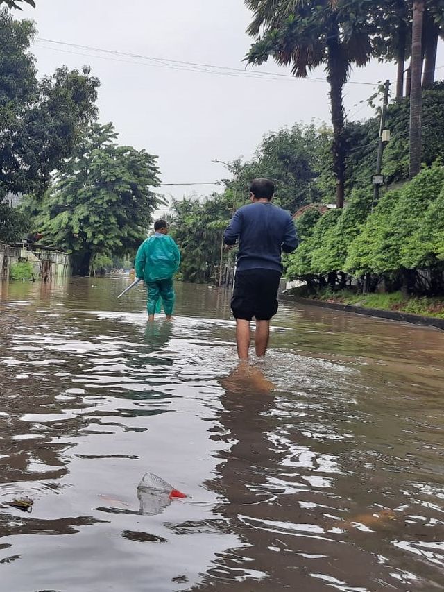 Warga berjalan melintasi banjir di Pulomas, Jakarta Timur, Sabtu (8/2).  Foto: Andreas Ricky Febrian/kumparan 