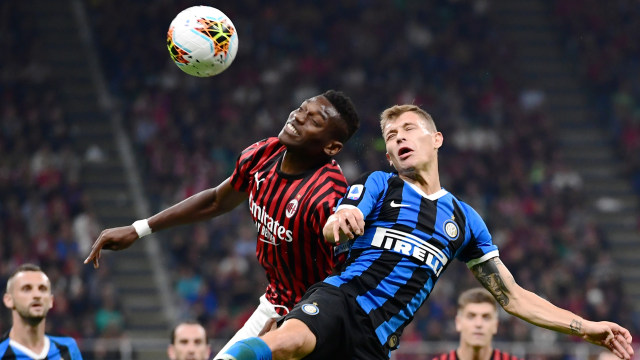 Pemain Inter Milan Nicolo Barella berebut bola dengan pemain AC Milan Rafael Leao pada Derby della Madonnina di San Siro. Foto: AFP/Miguel MEDINA