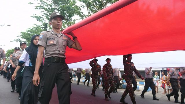 Ribuan peserta kirab mengarak bendera merah putih sejauh 2 kilometer menuju alun-alun Wijaya Kusuma Kota Sampang, Sabtu (8/2/2020) pukul 16.00 WIB. (Ryan/MM).
