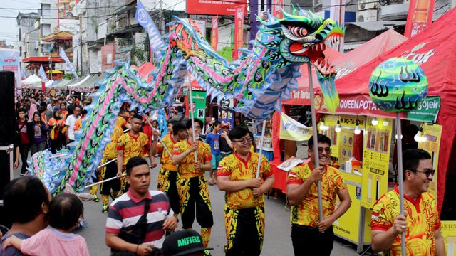 Warga menonton atraksi liong saat festival "Jappa Jokka Cap Go Meh di Makassar, Sulawesi Selatan, Sabtu (8/2). Foto: ANTARA FOTO/Arnas Padda