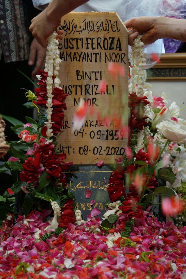 Keluarga meletakan bunga di atas papan nisan Istri Chrisye, Yanti Noor. Foto: Jamal Ramadhan/kumparan