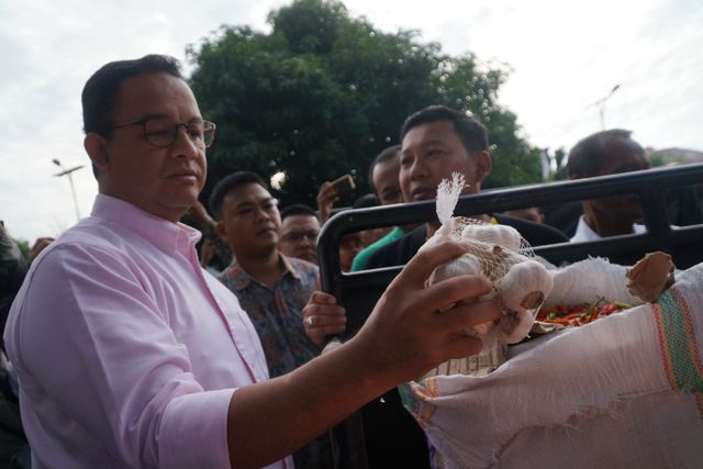 Gubernur DKI Jakarta, Anies Baswedan mengecek bawang putih saat melepas komoditas cabai dan bawang putih ke 22 pasar di Jakarta. Foto: Jamal Ramadhan/kumparan