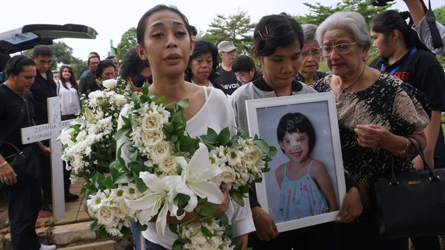 Karen (kiri) menghadiri prosesi pemakaman anaknya, Zefania Carina, di TPU Tanah Kusir, Jakarta Selatan, Minggu (9/2).
 Foto: Fanny Kusumawardhani/kumparan