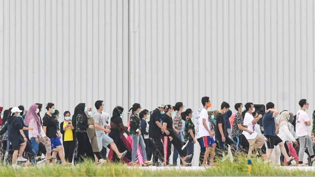 WNI yang dievakuasi dari Wuhan, Hubei, China melakukan senam bersama prajurit TNI pada hari kesembilan di Hanggar Pangkalan Udara. Foto: ANTARA FOTO/M Risyal Hidayat