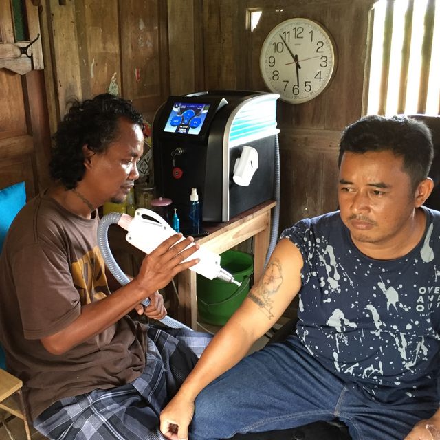 Prihanggono atau Pri Beruntung saat menghapus tato pengunjung di Warung KongSuu di Desa Widodomartani, Kabupaten Sleman, DI Yogyakarta, Senin (10/2). Foto: Arfiansyah Panji Purnandaru/kumparan