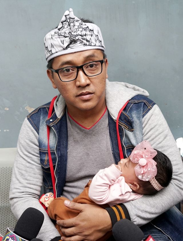 Suami almarhum Lina Jubaedah, Teddy, saat menggendong anaknya, di kawasan Tendean, Jakarta, Senin, (10/2/2020). Foto: Ronny