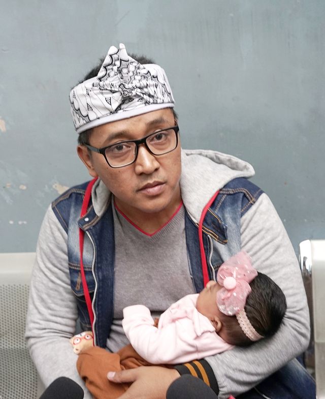Suami almarhum Lina Jubaedah, Teddy, saat menggendong anaknya, di kawasan Tendean, Jakarta, Senin, (10/2/2020). Foto: Ronny