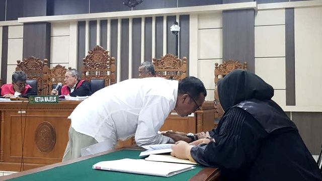 Staf khusus Bupati Kudus, Agoes Soeranto, berkonsultasi dengan penasihat hukumnya saat sidang di Pengadilan Tipikor Semarang. Foto: ANTARA/ I.C.Senjaya