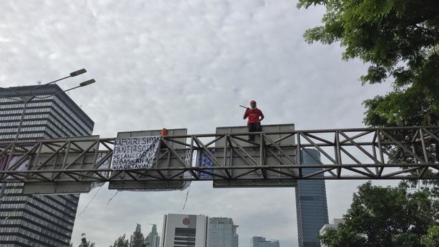 Aksi Agustinus Waru memanjat penunjuk jalan