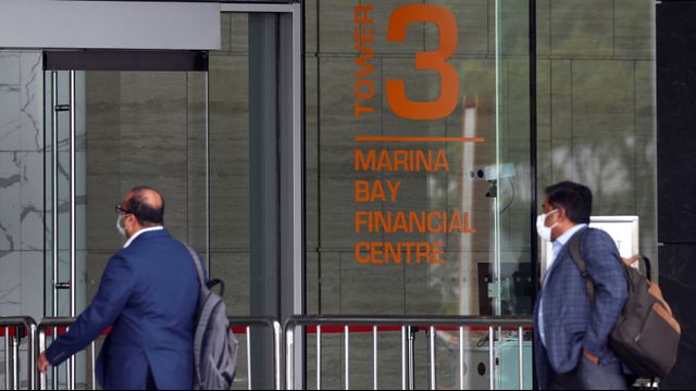 Dua orang pengunjung meninggalkan gedung Marina Bay Financial Centre Tower 3 tempat kantor pusat DBS berlokasi di Singapura. Foto: REUTERS / Edgar Su