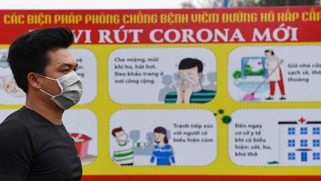 Warga mengenakan masker saat melintas di komune Son Loi di provinsi Vinh Phuc, Vietnam. Foto: AFP/NHAC NGUYEN