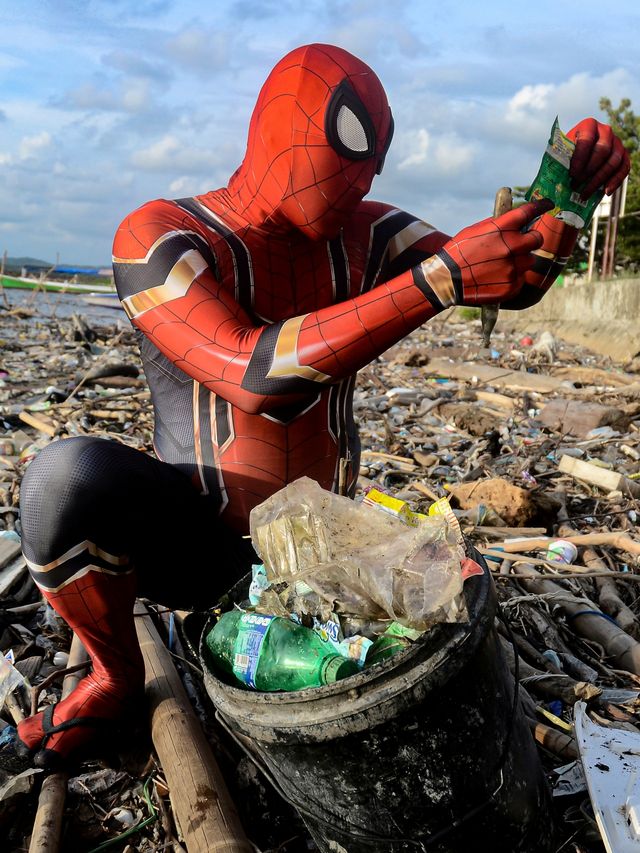 Rudi Hartono, seorang pria berpakaian kostum Spiderman, mengumpulkan sampah di sebuah pantai di Pare-Pare, provinsi Sulawesi Selatan, Indonesia. Foto: REUTERS/Stringer